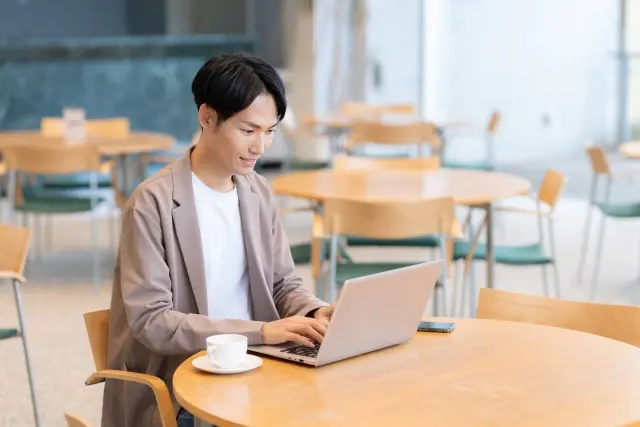 カフェでノートパソコンを使っているシーン